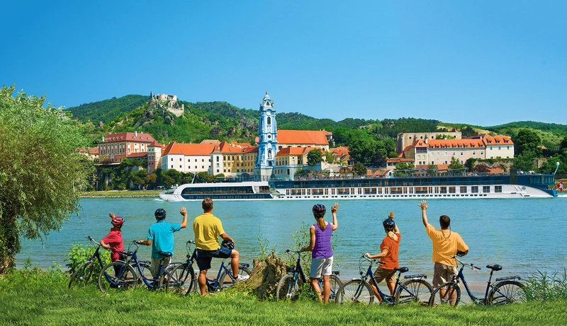 Guests wave to AmaPrima during their Dürnstein bike tour